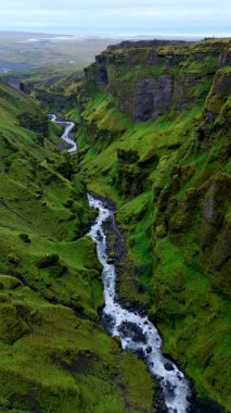 İzlanda 'da gizli bir mücevher olan Mulagljufur Kanyonu' nun büyüleyici kayalıklarını ve yemyeşil bahçelerini keşfedin. Kanyon boyunca kıvrılan bir nehir yılanı, saf güzellikleri sergiliyor..