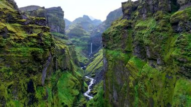 Mulagljufur Kanyonu 'nun dramatik uçurumlarını keşfedin, yemyeşil yamaçların çağlayan şelalelerle buluştuğu, büyüleyici bir doğa harikası oluşturduğu. İzlanda 'nın vahşi doğasının dinginliğini hissedin..