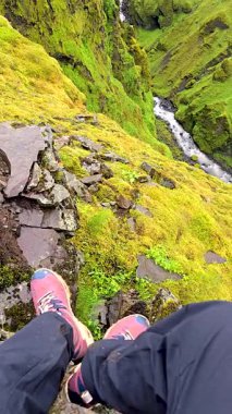 Mulagljufur Kanyonu İzlanda doğası yemyeşil bir kanyonun kenarında dururken. Canlı yosunlar ve akan suyla çevrelenmiş olan doğa sanatsal özellikleri tam olarak sergileniyor..