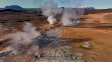 İzlanda 'daki Hver' in gerçeküstü manzarasına tanık olun. Kaynayan jeotermal kaynaklardan buhar yükseliyor..