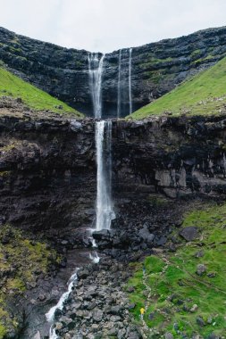 Fossa şelalesi Faroe Adaları 'ndaki yemyeşil tepelerle çevrili yüksek kayalıklardan zarifçe düşer. Dramatik manzara doğa güzelliğini en iyi şekilde sergiler..
