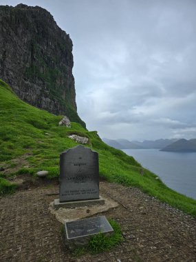 Kallur Deniz feneri, Kalsoy Adası, Faroe Adaları, 7 Temmuz 2025, James Bond anıtı dalgalı yeşil tepeler ve çalkantılı okyanus zeminine karşı duruyor..