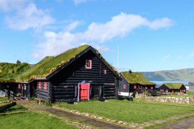 Faroe Adaları 'ndaki çim çatılı geleneksel siyah evlerin cazibesini deneyin. Kirkjubour Köyü