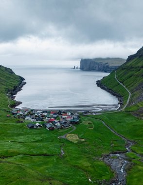Çarpışan kayalıklar ve sakin bir körfez arasında yer alan Faroe Adaları 'ndaki bu pitoresk köy canlı yeşil manzaralar arasında renkli evler sergiliyor. Tjornuvik Köyü