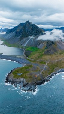 Göz kamaştırıcı İzlanda manzarasına dalmak bulutlar, engebeli kıyı şeritleri ve canlı yeşil manzaralarla kaplı yüksek gökdelenli dağlara. Hvalnes Doğa Koruma Alanı İzlanda