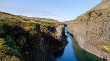 İzlanda engebeli topraklarına yerleşmiş Studlagil Kanyonu zümrüt sularından yükselen zarif bazalt sütunlara sahiptir..