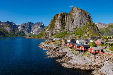 Norveç 'in engebeli kıyı şeridi boyunca uzanan büyüleyici kırmızı kulübeler bölgenin canlı kültürünü yansıtıyor. Hamnoy, Lofoten, Norveç 'teki balıkçı köyü