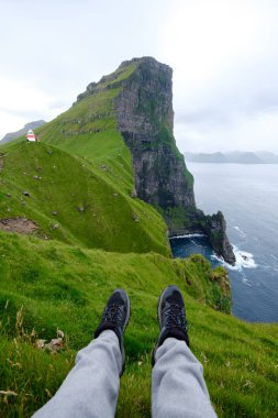 Faroe Adaları 'ndaki Atlantik Okyanusu üzerinde çarpıcı uçurumlar yükselir. Kallur Deniz Feneri, Kalsoy Adası