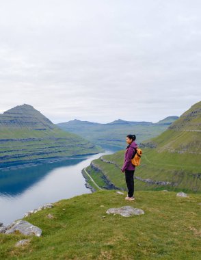Gezgin, Faroe Adaları 'ndaki Gonguturur Hvithamar Patikası boyunca yemyeşil tepelerin ve sakin suların nefes kesen manzarasından hoşlanır. Maceracılar ve doğa meraklıları için mükemmel bir an..