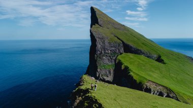 Faroe Adaları 'nın nefes kesen Mylingur uçurumlarını keşfedin. Ziyaretçiler doğanın güzelliğinden zevk alır..
