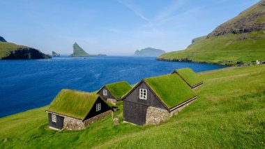 Bereketli yeşil tepeler, Faroe Adaları 'nın doğal güzelliklerini gözler önüne seren çimenli çatıları olan büyüleyici evleri kucaklıyor. Gök mavisi sular ve dramatik uçurumlar pitoresk bir Bour Village yaratır.
