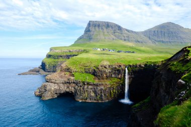 Faroe Adaları 'ndaki Gasadalur köyünün göz kamaştırıcı manzarasıyla çevrili Atlas Okyanusu' na çarpıcı bir şekilde inen Mulafossur Şelalesi 'ni keşfedin..