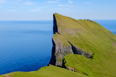 Büyüleyici Mylingur kayalık oluşumları, Faroe Adaları 'ndaki Kuzey Atlantik Okyanusu' nun kristal berraklığında sularının üzerinde yükselir..
