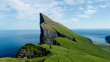 Mylingur kayalıkları Faroe Adaları 'ndaki okyanustan keskin bir şekilde yükselir ve yemyeşil manzaralarla çevrilidir. Yalnız bir yürüyüşçü bu çarpıcı araziyi keşfeder, doğadaki maceranın özünü yakalar..
