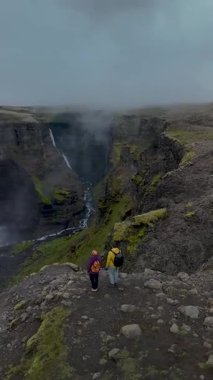 İki yürüyüşçü engebeli bir kanyonu geçerken İzlanda 'nın nefes kesici güzelliğini keşfedin. Görkemli Haifoss şelaleleri sarp kayalıklardan aşağı süzülür, sisle kaplanır ve sakin bir atmosfer oluşur. Macera bekliyor..