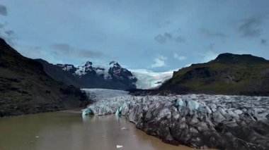 Buzul oluşumlarının dinamik bir gökyüzü altında dramatik dağ manzaralarıyla buluştuğu İzlanda 'daki nefes kesici Svinafellsjokull Buzulu' nu keşfedin. Tüm gezginler için görülmesi gereken bir doğa harikası..