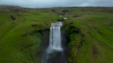İzlanda 'daki yemyeşil vadiye çarpıcı bir şekilde dalan Skogafoss şelalesine tanık olun.