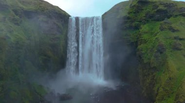 İzlanda 'daki çarpıcı Skogafoss şelalesini keşfedin. Suyun yeşil yeşilliklerle çevrili kayalıkların üzerinden düştüğü yer. Doğayı sevenler ve maceracılar için nefes kesici bir doğa harikası..