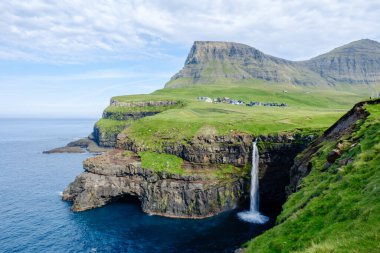 Mulafossur Şelalesi, çarpıcı Faroe Adaları yakınlarındaki Gasadalur köyü yakınlarındaki yemyeşil uçurumlarla çevrili Atlantik Okyanusu 'na çarpıcı bir şekilde akmaktadır..