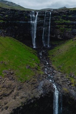 Faroe Adaları 'nın manzaralı manzaralarına yerleşen Fossa Şelalesi dramatik bir şekilde yemyeşil bir vadiye dönüşür. Çevredeki yeşillik bulutlu bir günde doğal güzelliği arttırır..