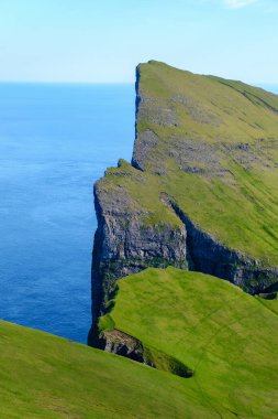 Okyanustan yükselen Mylingur kayalıkları Faroe Adaları 'nın çarpıcı manzarasını gözler önüne seriyor. Canlı yeşil çimenler derin mavi denizle çelişiyor ve nefes kesici bir manzara yaratıyor..