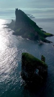 Faroe Adaları 'nın Atlantik Okyanusu' nun sakin sularında süzülen Drangarnir uçurumunun çarpıcı hava perspektifi