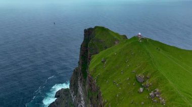 Uçsuz bucaksız Kuzey Atlantik Okyanusu ile çevrili Kalsoy 'un çarpıcı uçurumlarını keşfedin. Bu sırada engebeli tepelerin tepelerinde tuhaf bir deniz feneri gururla durur ve manzaranın olağanüstü manzarasını sunar..