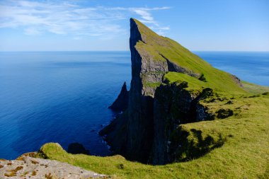 Faroe Adaları 'nın dramatik Mylingur uçurumlarına gidin. Orada yemyeşil tepeler canlı mavi Kuzey Atlantik Okyanusu ile kesişir. Mükemmel hava nefes kesici manzaraları ve doğal güzellikleri gözler önüne seriyor..