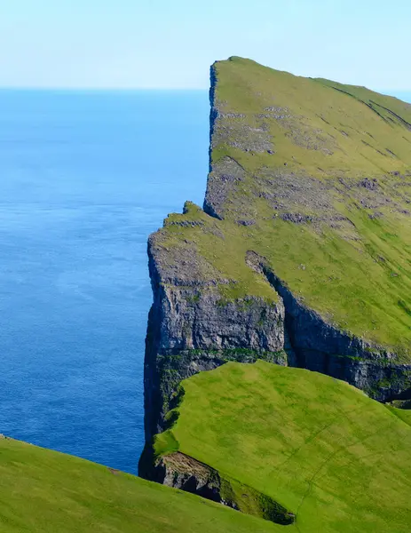 Mylingur uçurumu, Faroe Adaları 'nın yemyeşil otlarıyla kaplı Atlantik Okyanusu' ndan keskin bir şekilde yükselir.