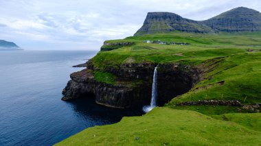 Vagar Adası 'ndaki Mulafossur Şelalesi' nin nefes kesici güzelliğini tecrübe edin. Temiz su Atlantik Okyanusu 'na çarpıcı bir şekilde akıyor..
