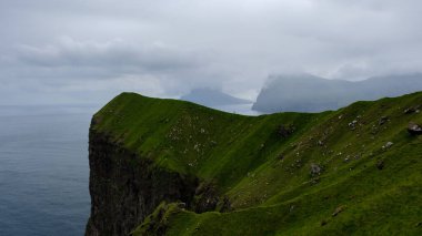 Denizle buluşan uçsuz bucaksız yeşil tepeler Faroe Adaları 'nda nefes kesici bir manzara yaratır. Enigmatik uçurumlar okyanustan dramatik bir şekilde yükselirken tek bir kişi bu çarpıcı araziyi keşfediyor. Kallur. 