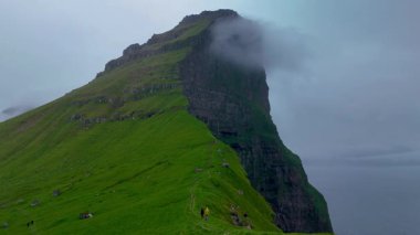 Kalsoy Adası 'nın nefes kesen arazisi sisle kaplanmış dramatik uçurumlar sergiliyor. Faroe Adaları 'nın bu büyüleyici yerini tanımlayan yeşil tepeleri ve dingin güzelliği keşfedin.