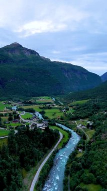 Bereketli yeşilliğin yüksek dağlarla buluştuğu Fortun Norveç 'in nefes kesici manzaralarını keşfedin. Huzurlu bir nehir bu pitoresk vadide kıvrılır, alacakaranlıkta güzellikler sergiler..