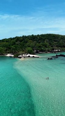 Yeşillik, Tayland 'daki Koh Kham Adası' nda turkuaz sularla birleşir. Göz kamaştırıcı kumsalları, sakin plajları, tatil yapan birkaç beyaz erkek ve Asyalı kadını keşfedin.