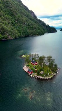 Norveç 'in göbeğinde, masmavi sularla çevrili yemyeşil bir adada büyüleyici bir kırmızı kulübe bulunur. Huzurlu fiyort, yüksek yeşil dağlar tarafından çerçevelenmiş doğada barışçıl bir kaçış sunar..