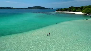 Tayland 'daki Koh Kham Adası' nın el değmemiş sahillerinde dinlenin. Turkuaz suların beyaz kumlu sahillerle buluştuğu yerde. Güneşlenmenin ve çarpıcı kıyı manzarasını keşfetmenin tadını çıkarın..