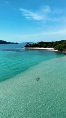 Explore the tranquil waters and sandy shores of Koh Kham Island in Thailand. Perfect for relaxation, this serene location invites visitors to enjoy the clear blue skies and stunning landscapes.
