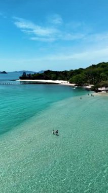 Discover the stunning paradise of Koh Kham Island, featuring tranquil turquoise waters, soft white sands, and lush greenery. a couple of caucasian men and Asian women on vacation