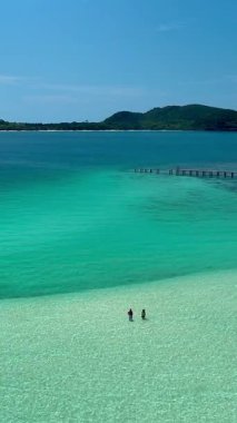 Experience the serene beauty of Koh Kham Island, Thailand. White sandy beaches and crystal-clear waters invite relaxation. a couple of caucasian men and Asian women on vacation