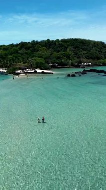 Immerse yourself in the beauty of Koh Kham Island, Thailand, where gentle waves lap against sandy shores. a couple of caucasian men and Asian women on vacation