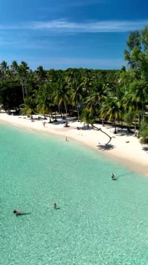 Captivating tropical paradise of Koh Kood showcases pristine white sand beaches and crystal clear waters, surrounded by lush palm trees. Perfect for a serene escape and relaxation.