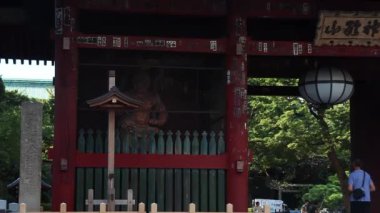 Gokokuji Budist tapınağının kapısında bir koruyucu tanrı. Kırmızı ahşap kapı. Tokyo manzarası. Japonya