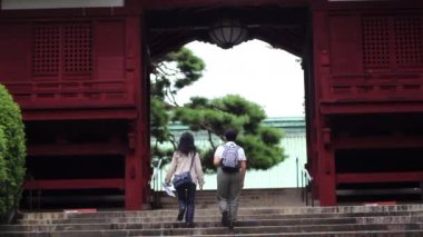 Turistler taş merdivenlerden Gokokuji Budist Tapınağı 'nın kapısına doğru yürüyorlar. Tokyo manzarası. Japonya