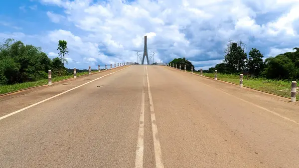 Cennete giden yol. Ekvator Ginesi 'nde kablo destekli modern bir köprüye giden asfalt bir yol..   