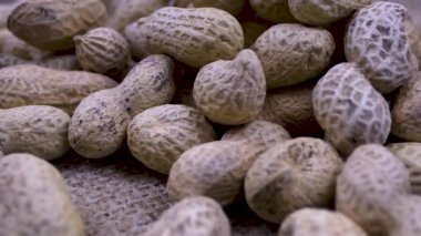 Fıstıkların detaylı dokusuna vurgu yaparak kabuktaki fıstıklara yakın çekim yap. Ayırt edici oyuklar ve pürüzlü doku doğal bir model yaratır. Sıcak bej ve kahverengi tonlar ürünün doğallığını vurgular..