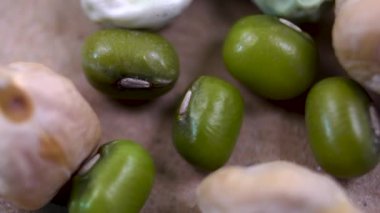 Çeşitli organik baklagillere yakın plan: yeşil mung fasulyeleri, nohut ve bezelyeler dengeli beslenme için sağlıklı bileşenler.