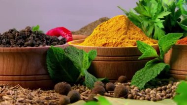 Ahşap kaselerde yemek pişirmek için çeşitli doğal baharat ve otlar: kırmızı biber, nane, zerdeçal, karabiber, defne yaprağı.