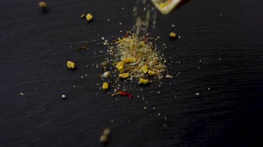 Koyu dokuya dökülen yeşil ve sarı bitki ve baharat karışımı: kişniş, fesleğen, dereotu, defne yaprağı, safran, çemen otu. Gürcistan baharat karışımı