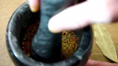 Siyah taş havan mermisiyle öğütülmüş baharatlar. Havanda Öğütücü Aromatik Baharatlar