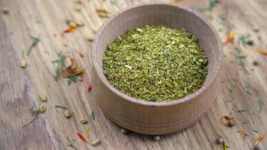 Kapatın. Ahşap bir kasede kuru aromatik baharatların karışımı. Köy ahşap bir kaseyi dolduran baharat karışımının ayrıntılı görüntüsü: kişniş, fesleğen, dereotu, defne yaprağı, safran, çemen otu..
